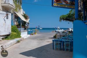 an empty street with tables and chairs and the ocean at Seaside Apartments in Emporeios