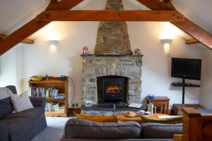 a living room with a stone fireplace and a couch at Ty Tatws Fishguard Pembrokeshire in Letterston