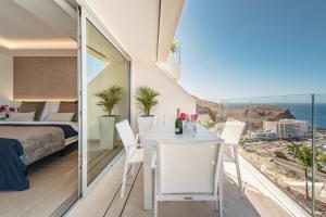 a bedroom with a bed and a table and chairs at Grand Horizon Luxury Boutique Apartments in Puerto Rico de Gran Canaria