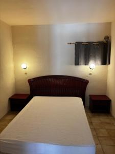 Bett in einem Zimmer mit zwei Lichtern an der Wand in der Unterkunft Bon Porto 2 in Cavalaire-sur-Mer + 2 Fotos