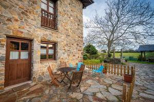 QuintanaにあるApartamentos Rurales Ca Xuacu La Antojanaのパティオ(テーブル、椅子付)
