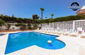 a swimming pool with lounge chairs and a pool at Villa del Mar in Torremolinos