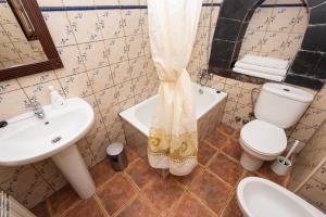 QuintanaにあるApartamentos Rurales Ca Xuacu La Antojanaの洗面台、トイレ、浴槽を備えたバスルーム +18枚の写真