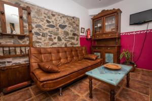 QuintanaにあるApartamentos Rurales Ca Xuacu La Antojanaの革張りのソファとテーブルのあるリビングルーム