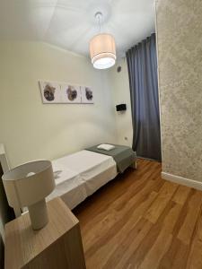 a small room with a bed and a lamp at La Finestra su San Lorenzo in Florence +6 photos