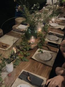 a long table with plates and candles and flowers at Dew&Plum 白露梅室 in Ruisui