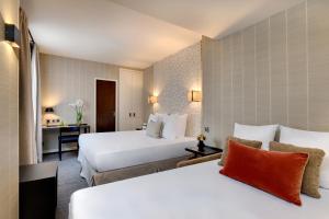 two beds in a hotel room at Le Senat in Paris
