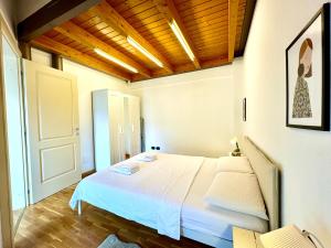 a bedroom with a white bed and a wooden ceiling at Little Loft in Timişoara