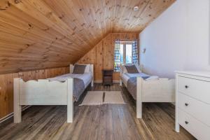 a bedroom with two beds and a wooden ceiling at Sporto ir poilsio centras KORNEALITA IEVALAUKIS in Gaveikėnai