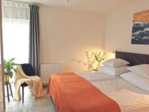 une chambre avec un lit, une chaise et une fenêtre dans l'établissement Apartamenty Wybrzeże Laguna Perła 5 Mórz Basen & SPA, SAT DE i EN, à Ustronie Morskie 15 autres photos