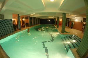 a large indoor swimming pool with people in it at Daisy Superior in Kraków
