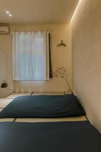 a room with a blue bed in front of a window at Dew&Plum 白露梅室 in Ruisui