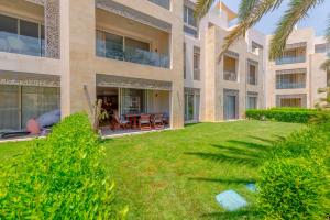a large building with a lawn in front of it at Elegant apartment with pool and beach access in Hurghada