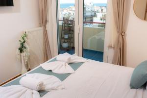 a bed with towels sitting on top of it at VDG Seafront Elegant Residence in Rethymno Town