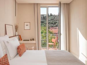 a bedroom with a bed and a balcony at Hôtel Liautaud Rooftop Cassis in Cassis