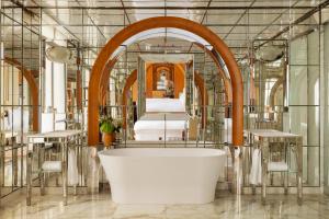 a bathroom with a bath tub and a bed at Hôtel Le Royal Monceau Raffles Paris in Paris