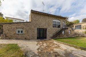 a stone house with a staircase on the side of it at El Calderillo in Burgohondo