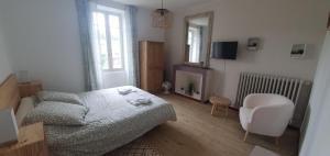 a small bedroom with a bed and a chair at Sous La Treille in Saze
