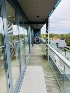 a corridor of a building with glass windows and a walkway at Daukanto Sea View Apartment, by luxuryrent in Palanga
