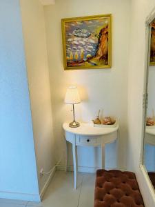 a room with a table with a lamp and a painting at Daukanto Sea View Apartment, by luxuryrent in Palanga