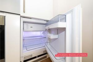 un réfrigérateur vide avec sa porte ouverte dans une cuisine dans l'établissement Mind Retreat Apartment, By Cohost, à Palanga 31 autres photos