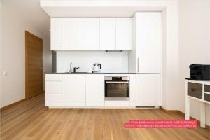 une cuisine blanche avec un évier et une cuisinière dans l'établissement Mind Retreat Apartment, By Cohost, à Palanga