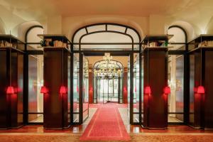 a lobby with a red carpet and glass doors at Hôtel Le Royal Monceau Raffles Paris in Paris +173 photos