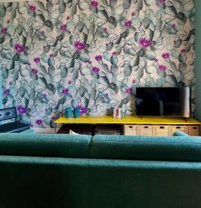 a living room with a couch and a wall with a wallpaper at Casa Flos31 in Catania