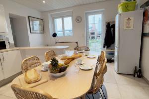 a kitchen with a table with a bowl of fruit on it at Villa Vendée EU in Saint-Michel-en-lʼHerm +2 photos