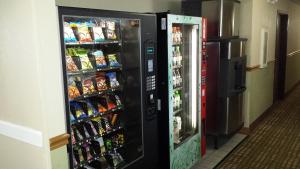 a soda vending machine next to a refrigerator at Park Inn by Radisson, Ames in Ames