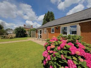 a house with pink flowers in the yard at Chevrons Living in Fordingbridge