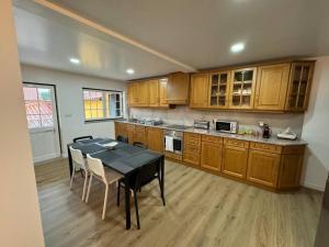 a kitchen with a table and a kitchen with wooden cabinets at XperienceHouse Janeiro in Janeiro de Cima