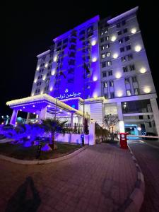 a large building with blue lights in front of it at Golden Tulip Al Khobar in Al Khobar