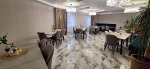 a dining room with tables and chairs and chandeliers at "Rush Hotel" in Astana +46 photos