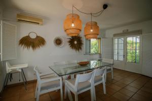 a kitchen with a glass table and white chairs at FLH Praia Verde Rooftop House in Praia Verde