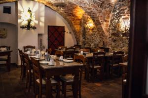 a dining room with tables and chairs and a stone wall at Hotel Italia in Görlitz