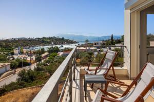 two chairs on a balcony with a view of the ocean at Ormos Sea View Apartment in Agios Nikolaos