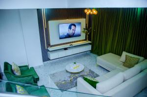 a living room with a couch and a tv at Tranquil Old Bodija Retreat - 3 Bedroom House in Ibadan
