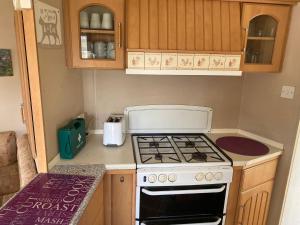 eine kleine Küche mit einem Herd und einer Arbeitsplatte in der Unterkunft 361 seawick in Saint Osyth