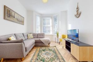 ein Wohnzimmer mit Couch und Flachbildfernseher in der Unterkunft Bright & Spacious 4 Bed Victorian Home by Blue Buzzard Property in Kent + 52 Fotos