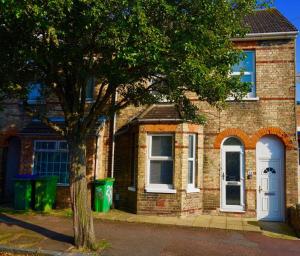 ein Backsteinhaus mit einem Baum davor in der Unterkunft Bright & Spacious 4 Bed Victorian Home by Blue Buzzard Property in Kent