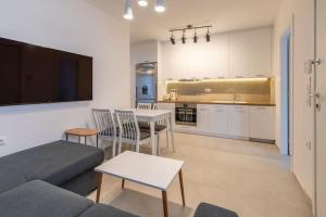 a living room with a couch and a table and a kitchen at Mykonos Luxury Apartment with Jacuzzi in Mýkonos City