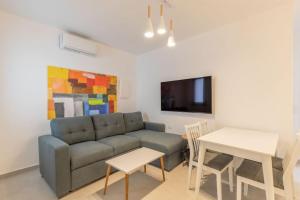 a living room with a couch and a table at Mykonos Luxury Apartment with Jacuzzi in Mýkonos City