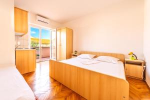 sypialnia z dużym łóżkiem z drewnianym zagłówkiem w obiekcie Apartments Matulo w Novalji