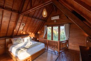 Un dormitorio abuhardillado con una cama y una ventana. en Aditara Sebatu Villa, en Ubud