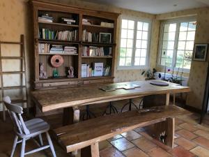 a wooden table with a bench in a room at Moulin sous la Vergne in Nanteuil-en-Vallée
