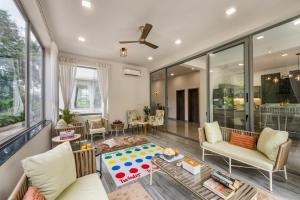 una sala de estar con un sofá y una mesa en SaffronStays Magnolia - 3BHK Moira Goa Villa with Pool & Games Room, en Bardez
