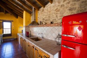 a kitchen with a red refrigerator and a sink at Hotel Rural La Torre de Bisjueces in Bisjueces