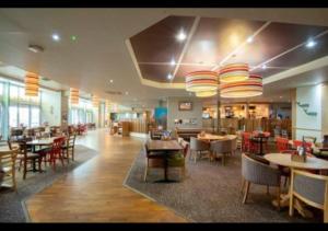 a dining room with tables and chairs and a restaurant at SBL48 Camber Sands Holiday Park in Camber