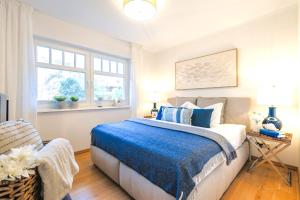 a bedroom with a bed with a blue blanket at Villa Strandleben in Zingst +17 photos